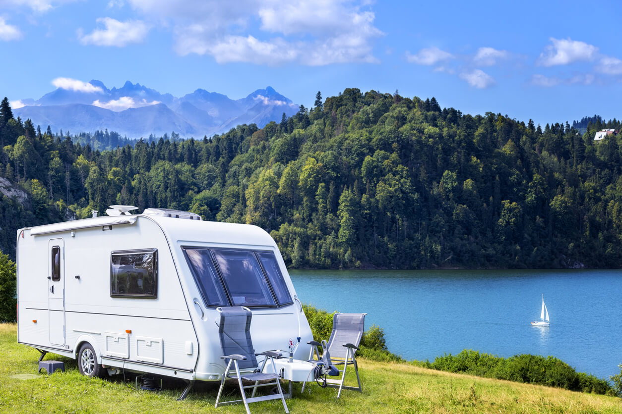 modern camper parked in front of a lake